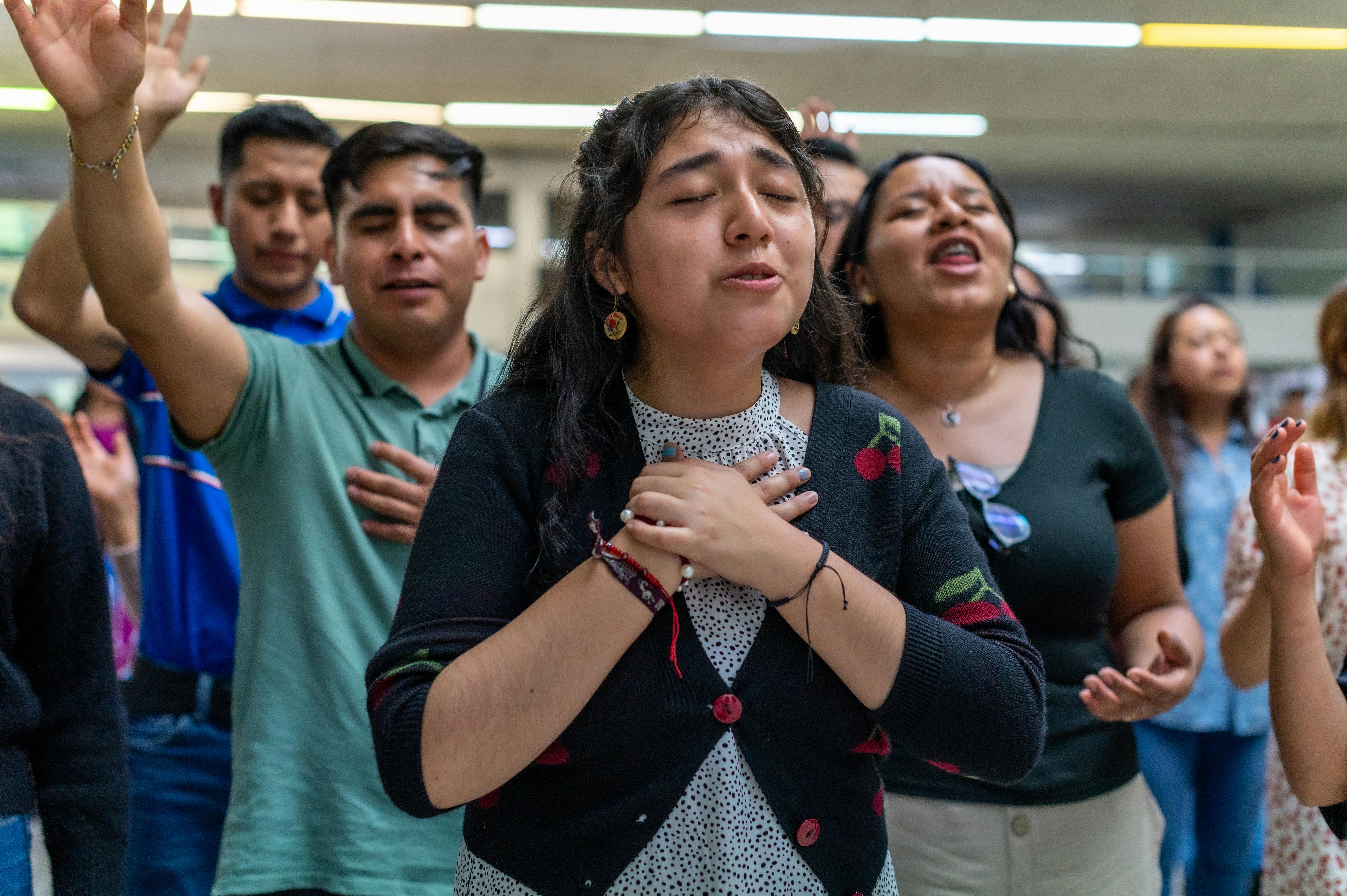 a group of people standing in a room with their hands raised