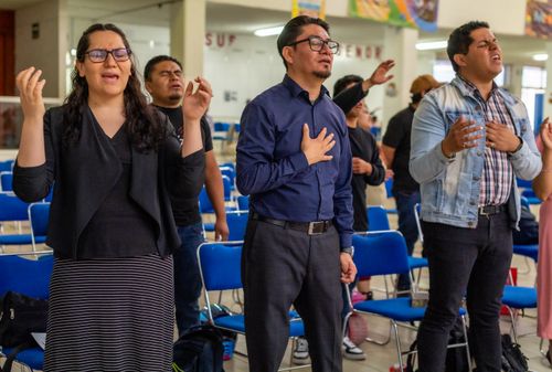 Free Individuals engaged in a worship session, expressing devotion and praise. Stock Photo