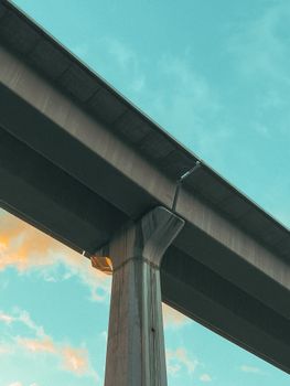 Low angle shot of a modern bridge structure against a vibrant sky.