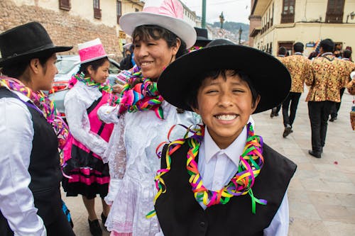 Group of People in Traditional Clothing Standing on a Street at a Parade 