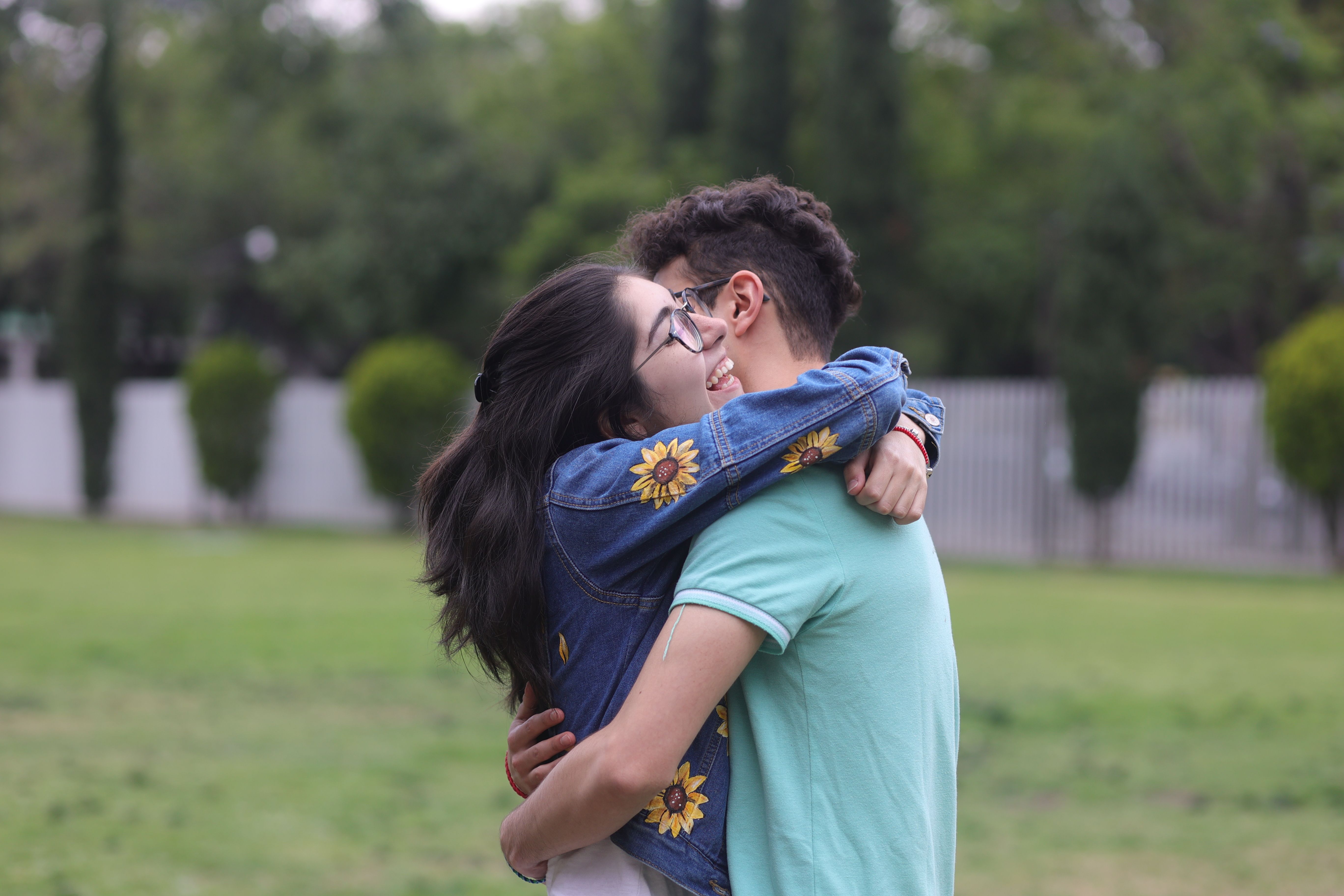 A man and woman are hugging each other in a park · Free Stock Photo