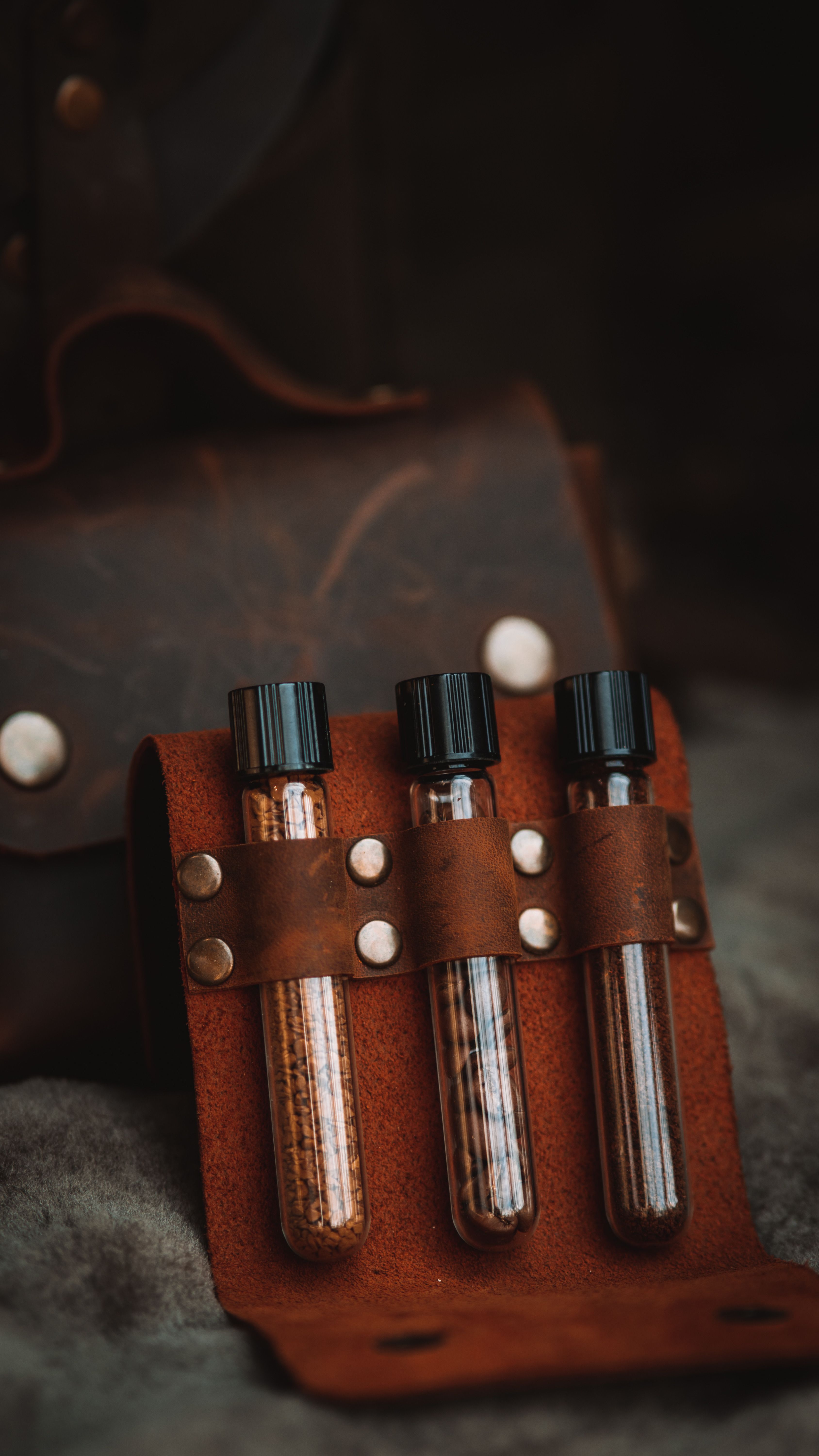 Close-up of Glass Ampules behind Leather Straps · Free Stock Photo