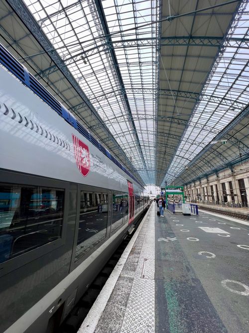 Free Interior view of Bordeaux Saint-Jean railway station featuring a modern passenger train and glass roof. Stock Photo