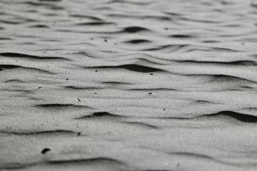 Black and white photo capturing the unique texture and patterns of sand dunes.