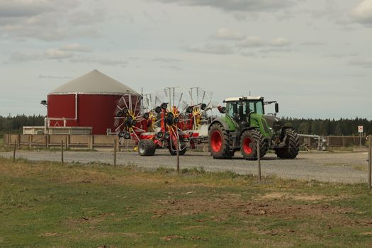 A modern tractor with rakes at a farm in Jönköping, Sweden captures the essence of contemporary agriculture.