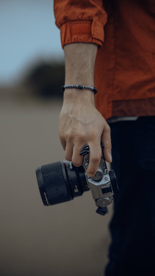 Close-up of a Man Holding a Camera in Hand 