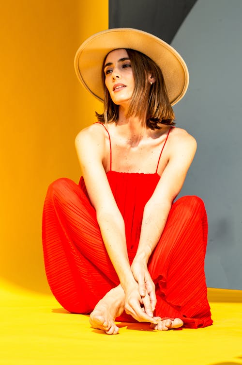 Woman in Hat and Red Dress Sitting 