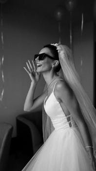 Chic and stylish bride wearing sunglasses in a modern wedding dress, exuding joy.
