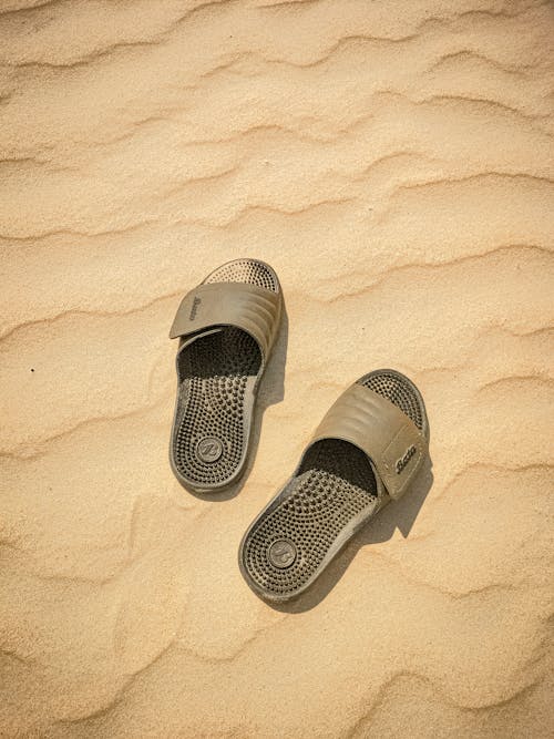 Photo of Gray Plastic Flip-Flops on the Sand