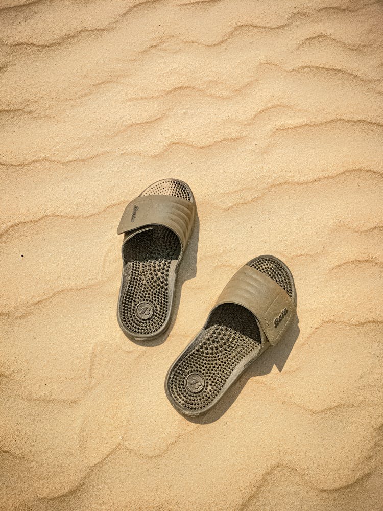 Photo Of Gray Plastic Flip-Flops On The Sand