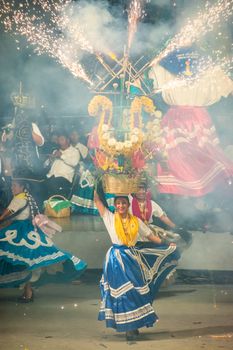 Celebratory traditional dance with colorful costumes and pyrotechnics in Oaxaca, Mexico.