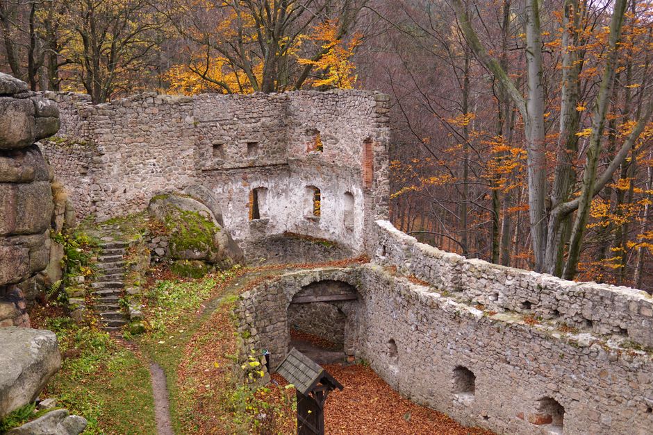 Explore the scenic ruins of a medieval fortress in Borzygniew, surrounded by a vibrant autumnal forest.