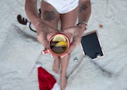 一位女士在铺着节日装饰的舒适毯子上，喝着柠檬茶，感受着冬日氛围