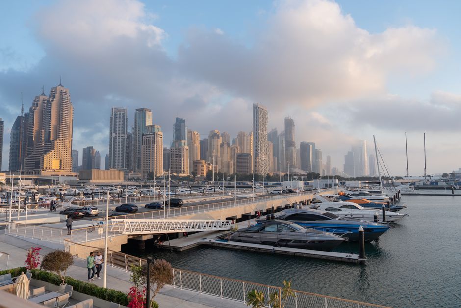 Stunning Dubai Harbor: Luxury Yacht Tour with BBQ Options Review 2026 - Tranquil marina with yachts and iconic Dubai skyscrapers under a cloudy sky.