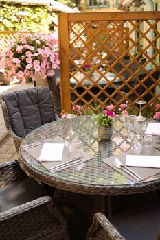 Elegant outdoor dining table on a patio with floral decor, perfect for alfresco meals.