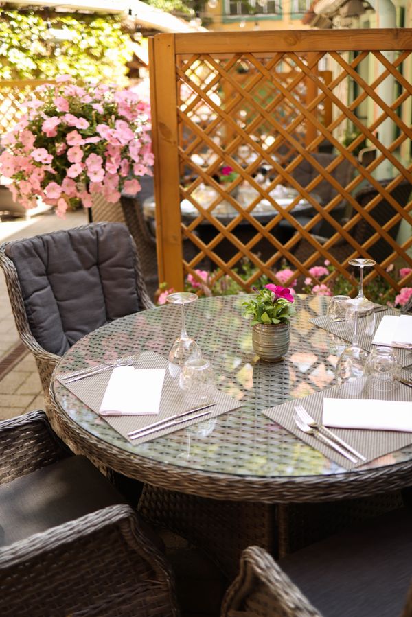 Outdoor dining table on a patio with floral decor — photo by Valeria Boltneva on Pexels