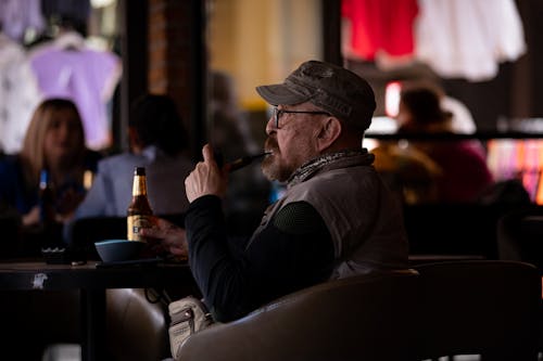 Man Smoking Pipe and Drinking Beer in Bar