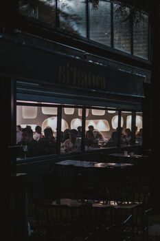 Ankara café at night showing people enjoying a cozy atmosphere through large windows.
