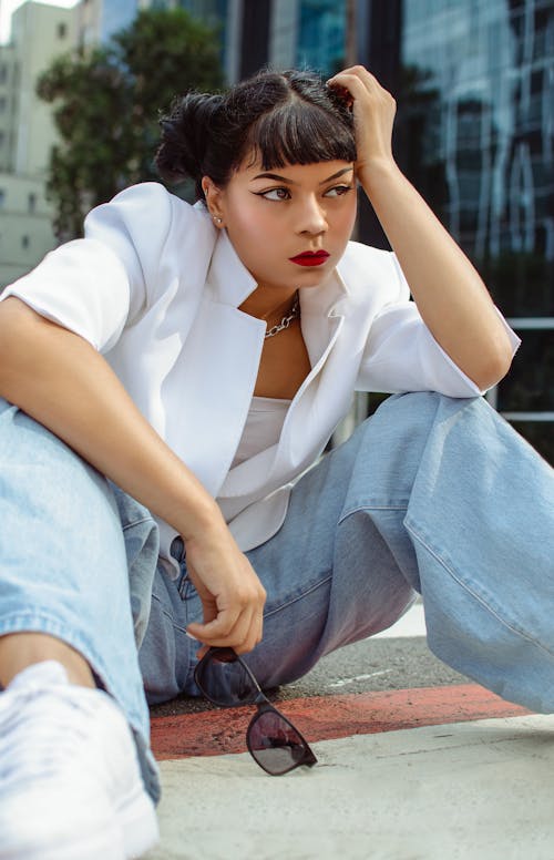 Sitting Woman in Jeans Posing in City