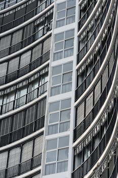 Close-up of a modern residential building facade featuring curved balconies and large windows.