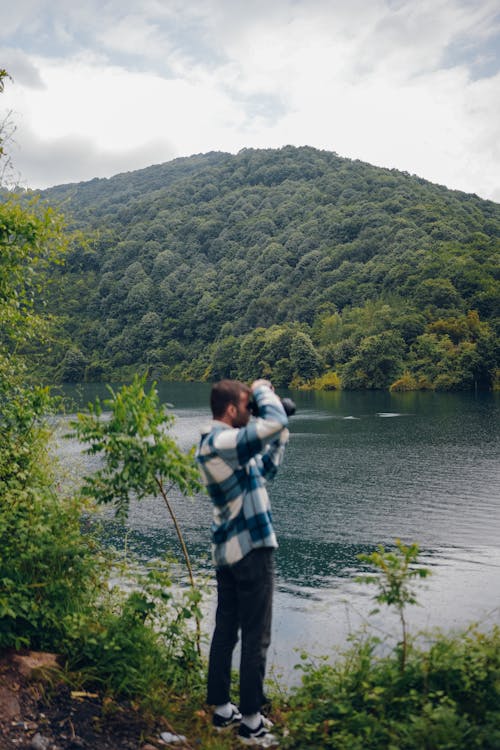 Man Taking Photo of Lake