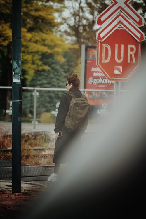 Woman with Backpack Standing by Stop Sign in Turkey
