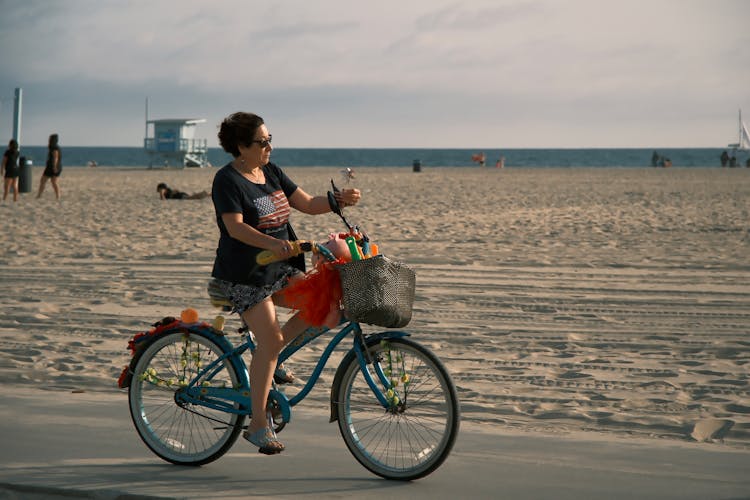 Woman Riding A Bicycle On The Beach 