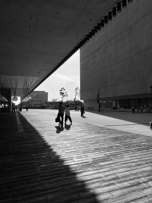 Free A black and white photo capturing people walking in an urban environment with modern architecture. Stock Photo