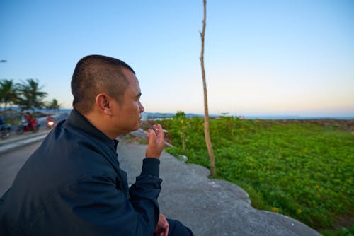 Free Man Sitting and Smoking Stock Photo