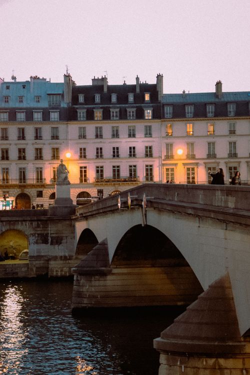 Free Scenic view of a Parisian bridge at dusk, capturing the city's classic architecture. Stock Photo