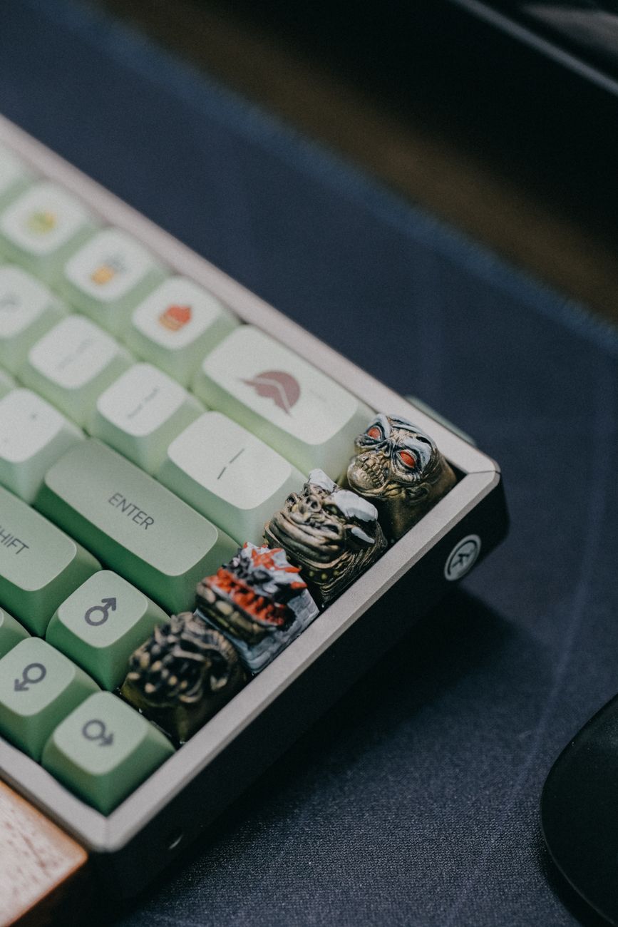 Close-up of unique skull keycaps on a mechanical keyboard with green keys.