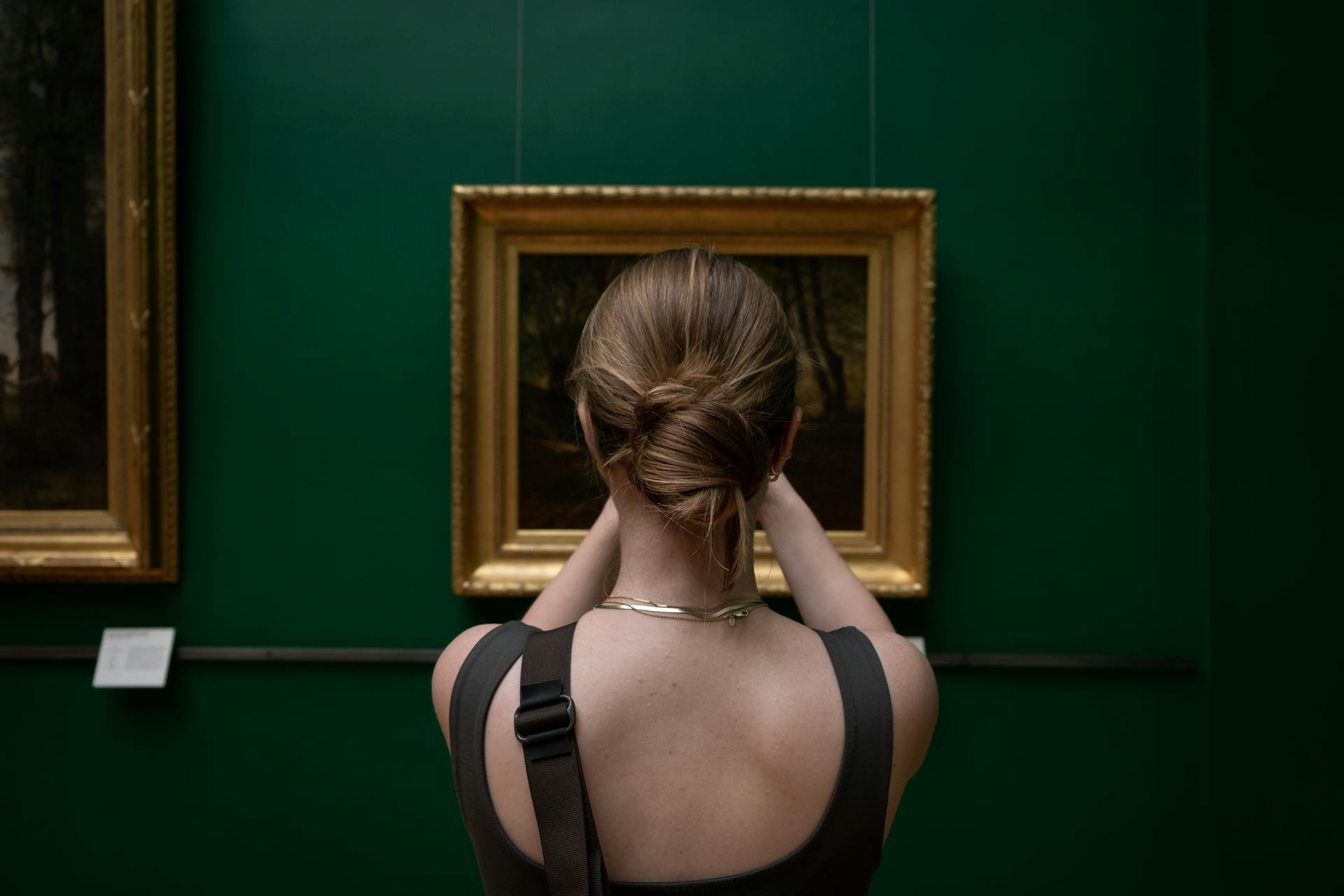 Photo of a Woman Taking Pictures of a Painting in an Art Gallery