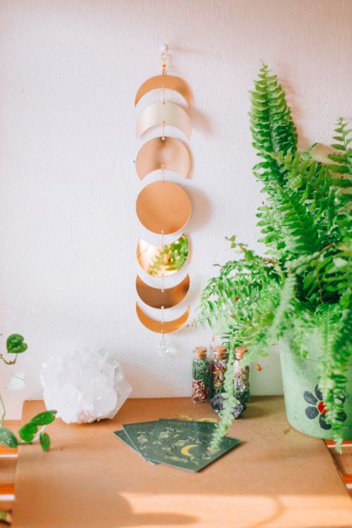 Free A cozy interior featuring a fern, crystal, wall hanging, and botanical prints. Stock Photo