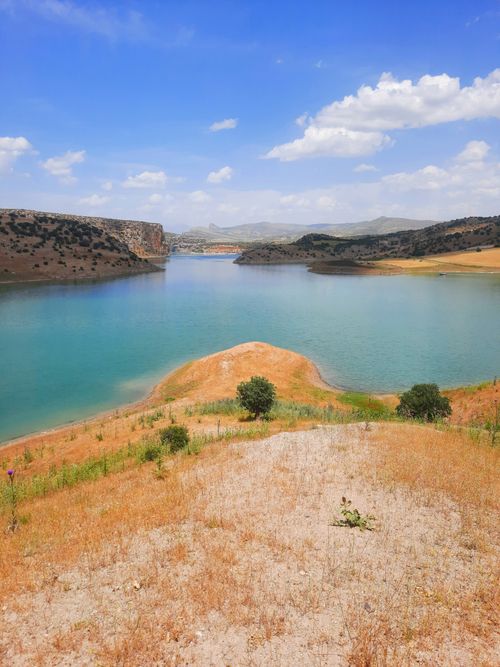 Free A tranquil lake surrounded by desert hills under a clear blue sky, captured outdoors. Stock Photo