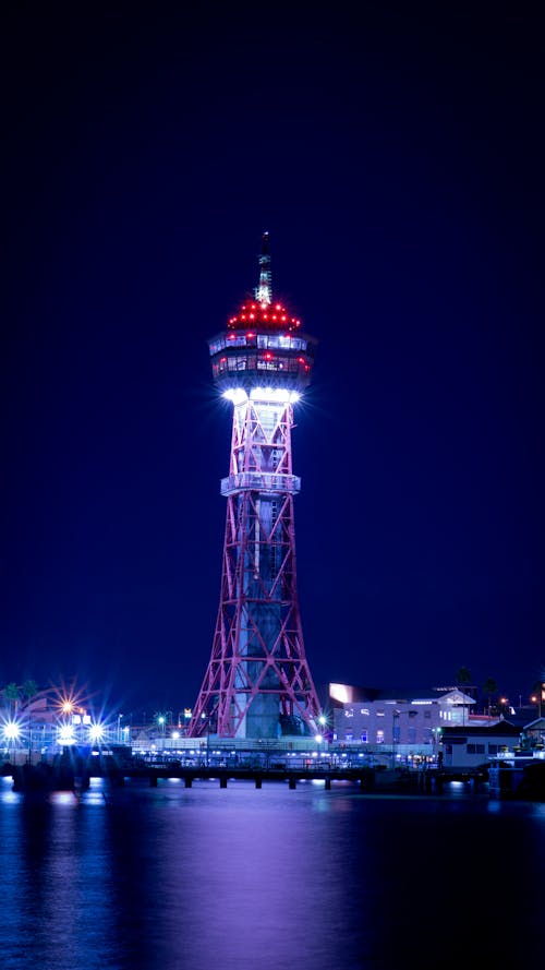 Lighted Concrete Tower Surrounded by Body of Water