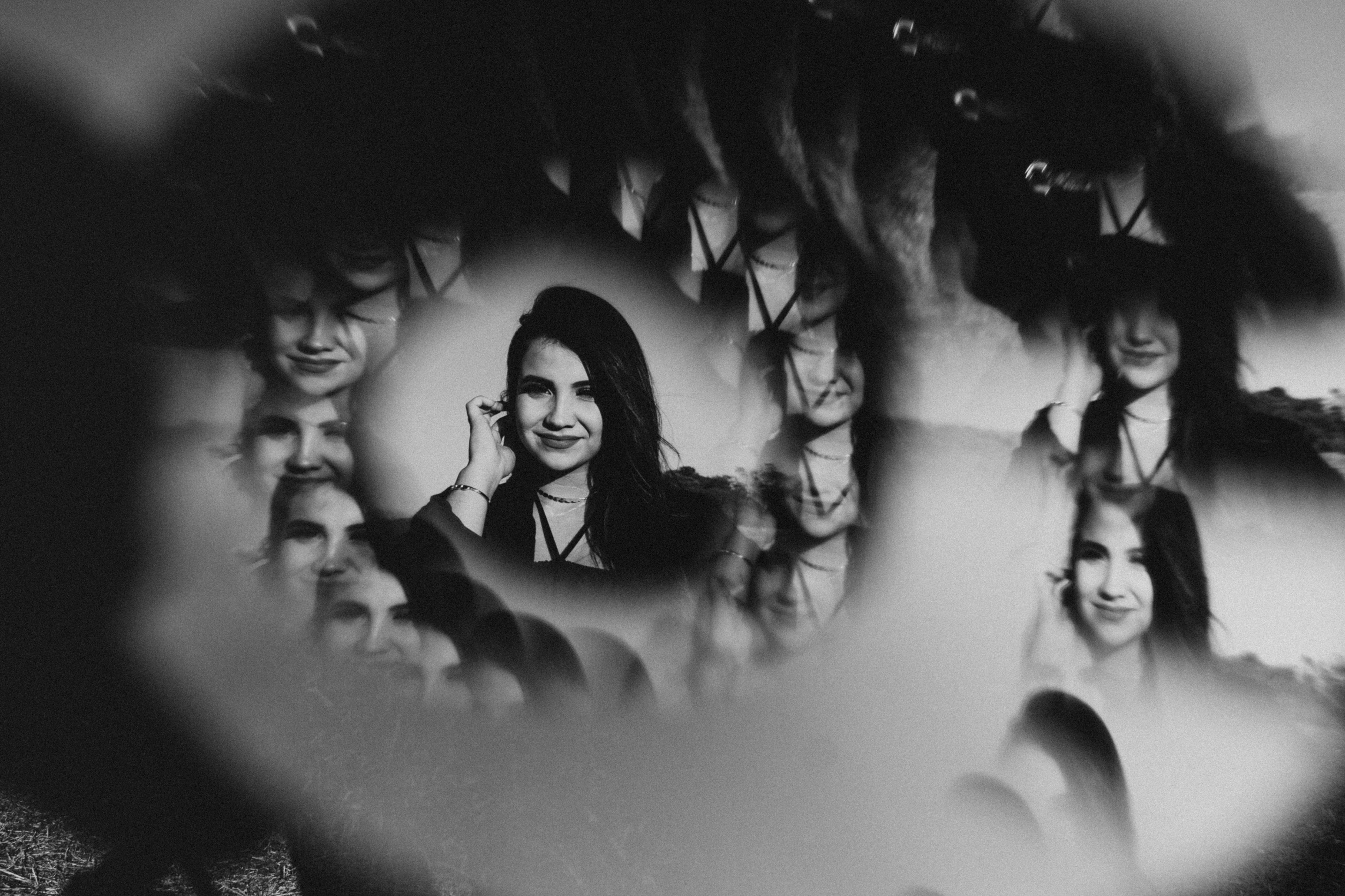 Free Black and white artistic portrait of a smiling woman with unique reflections, creating an abstract visual impact. Stock Photo