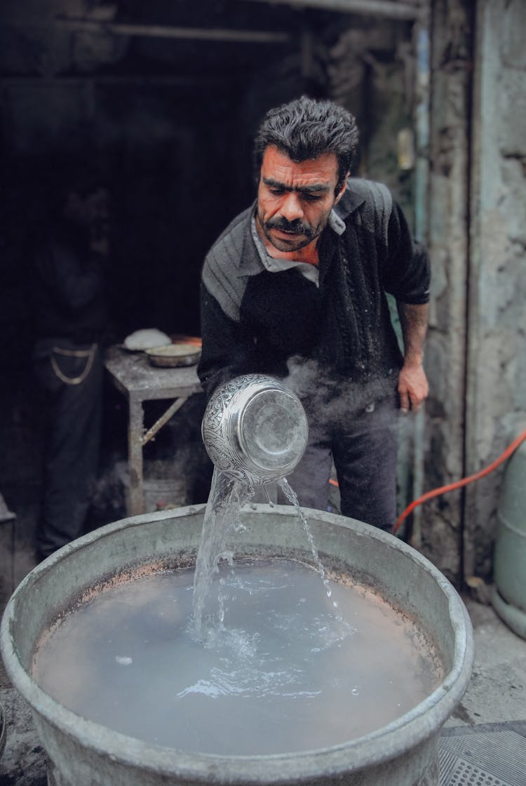 Man Cooling Pot In Water