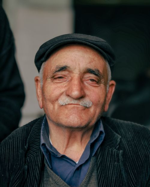Free Charming portrait of a smiling elderly man with a mustache and cap. Stock Photo