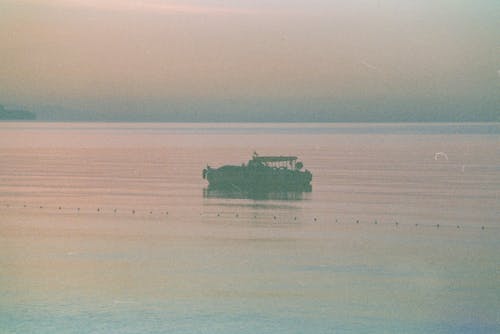 Photo of a Boat in the Sea at Dusk