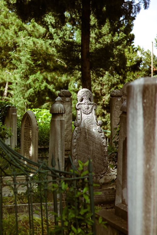 Free Explore the serene beauty of Ottoman-era tombstones in a lush cemetery in Bursa, Turkey. Stock Photo