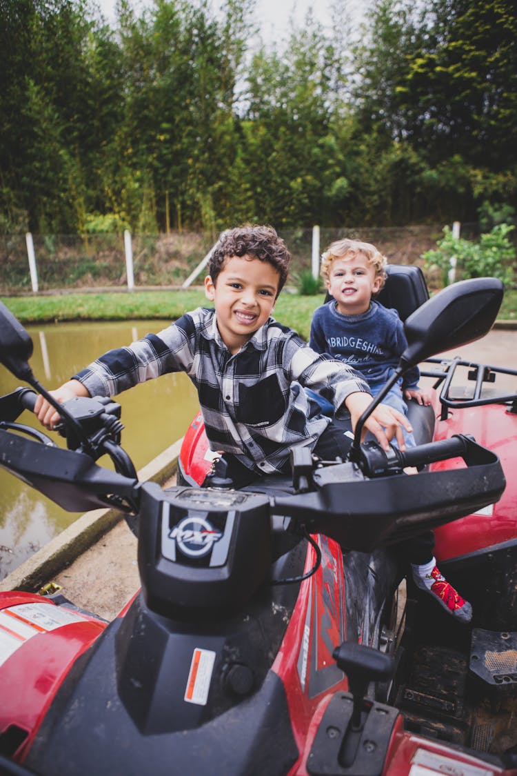 Smiling Boys Riding On Scooters