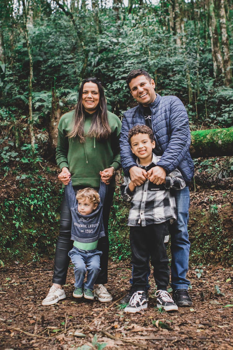 Smiling Parents With Children In Forest