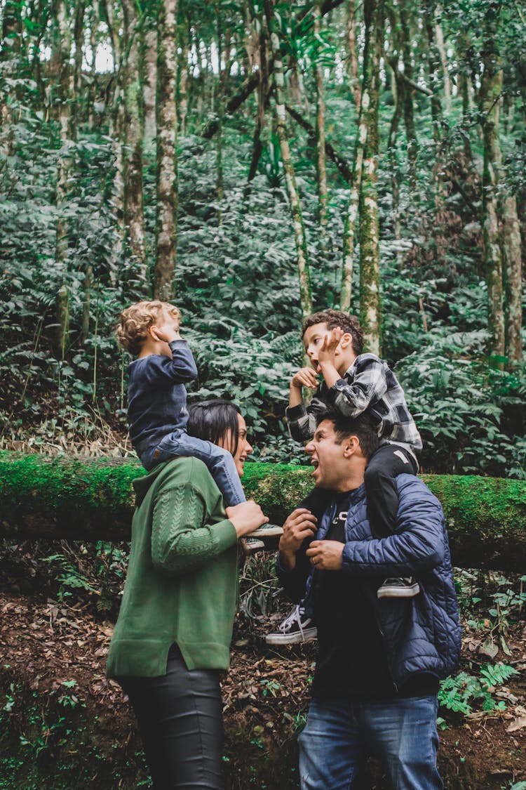 Smiling Parents With Children In Wild Forest