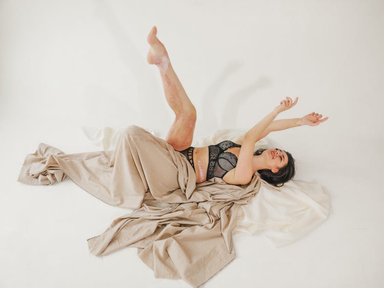 Woman Lying Down With Leg Raised In Underwear