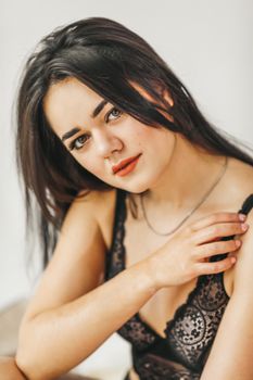 Beautiful brunette in black lace lingerie, close-up portrait.