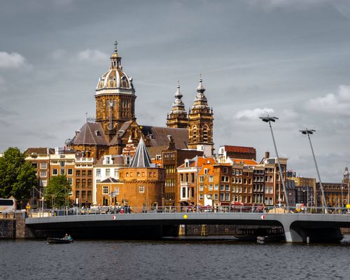 Captivating view of Basilica of Saint Nicholas by the canal in Amsterdam, showcasing historic architecture.