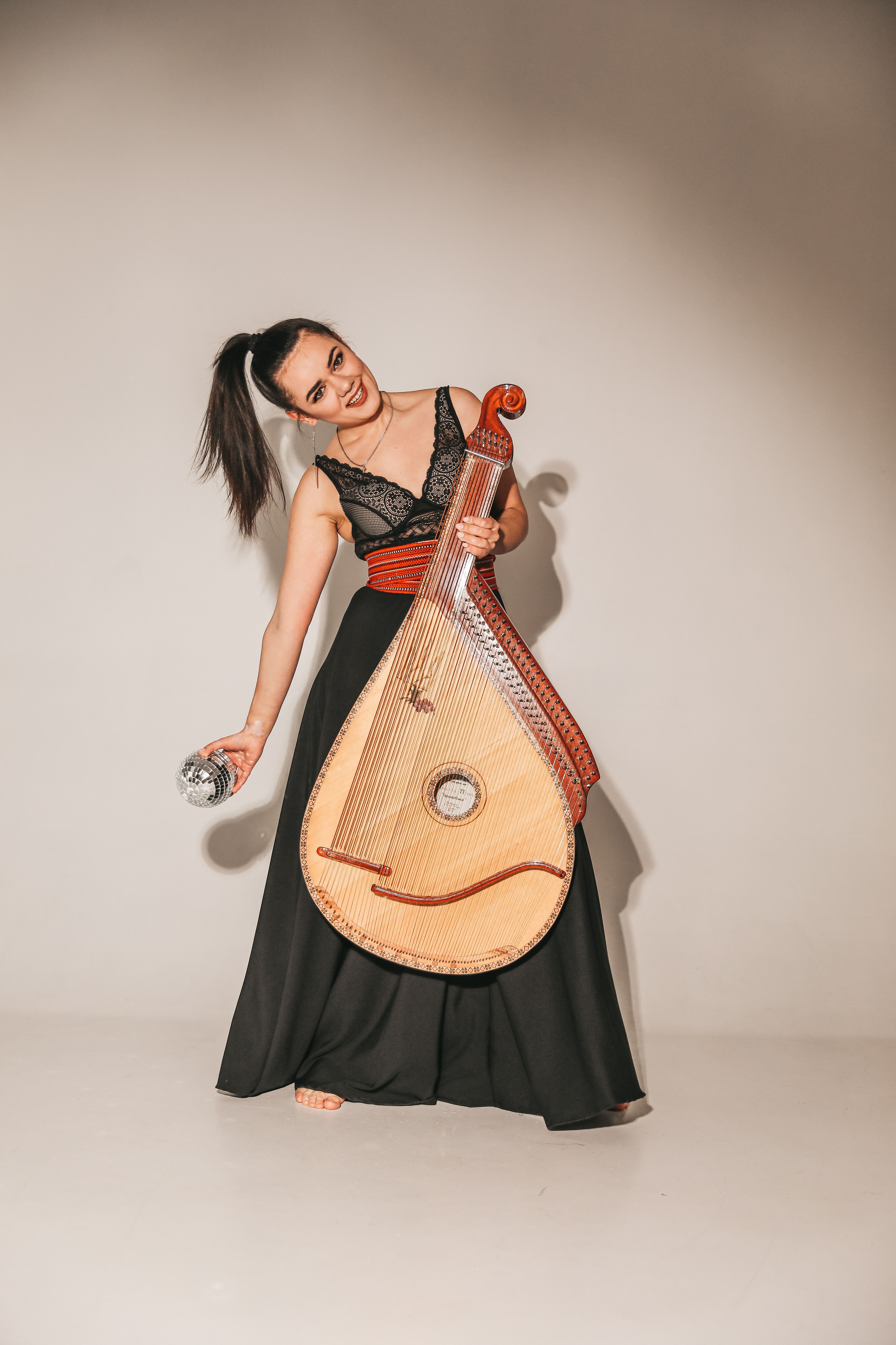 Woman in Black Dress Standing with Musical Instrument · Free Stock Photo