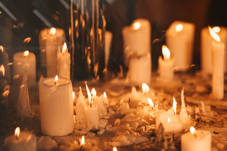 Soft candle flames creating a warm, relaxing atmosphere with melted wax.