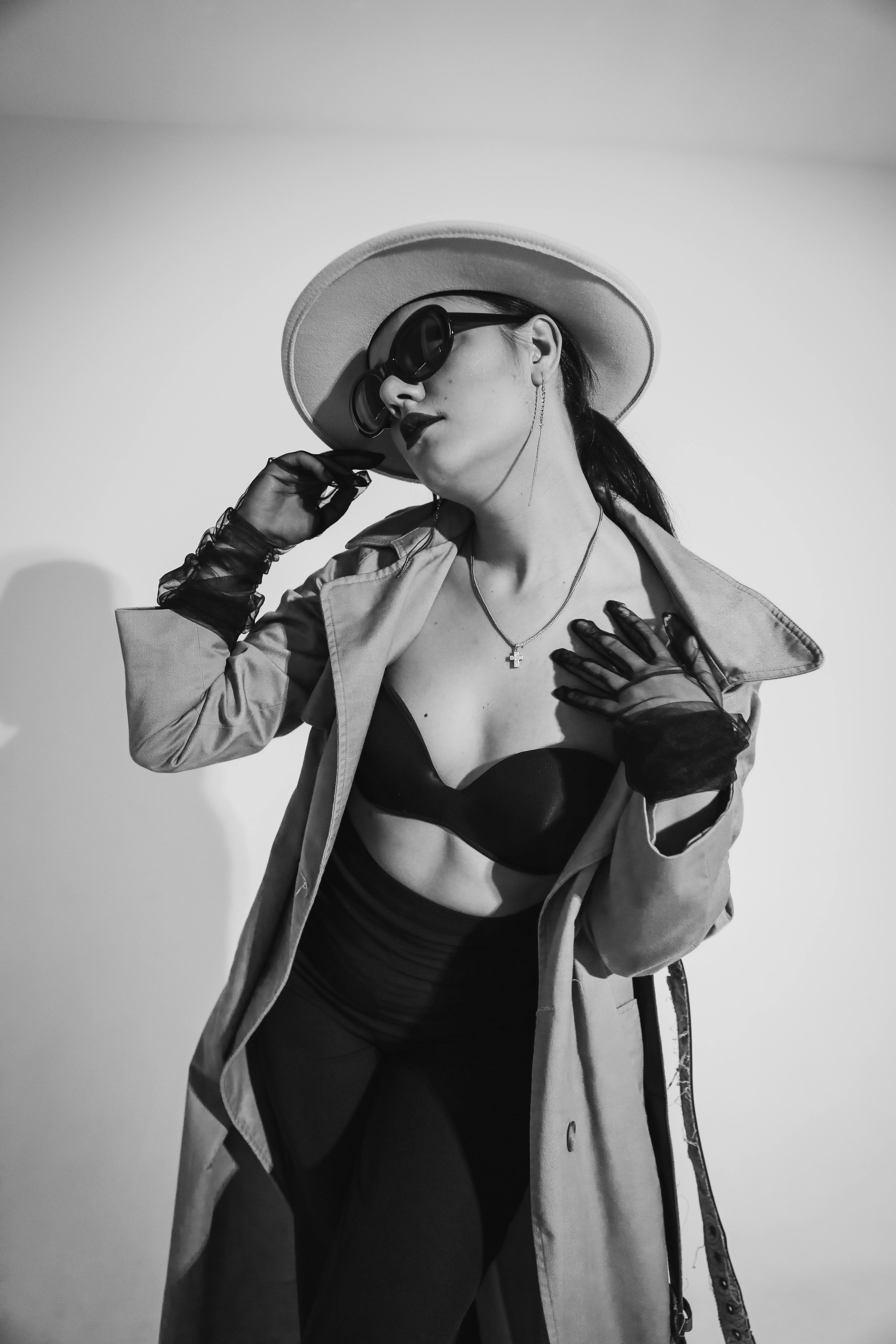 Free Elegant woman wearing fashion items like sunglasses, gloves, and hat in a stylish black and white portrait. Stock Photo