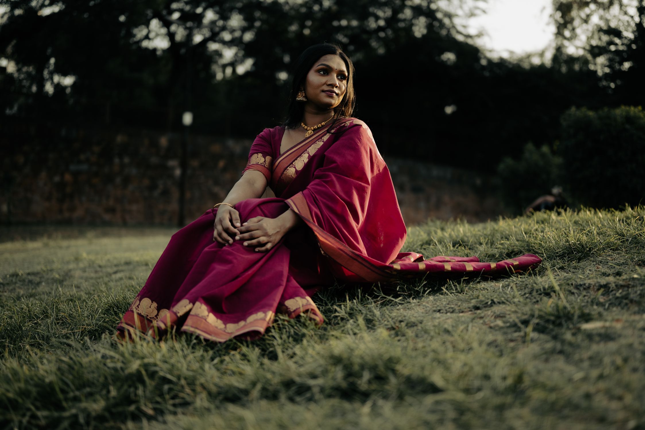 Young Woman in Traditional Dress Sitting on Grass · Free Stock Photo